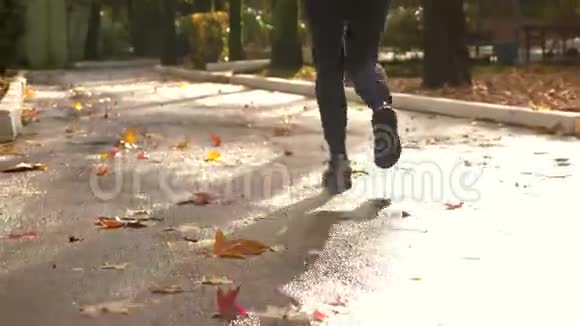特写镜头穿运动鞋的女腿在秋天公园的小径上跑步视频的预览图