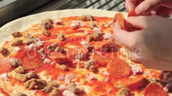 披萨店的厨师在沙拉米上做意大利香肠披萨视频的预览图