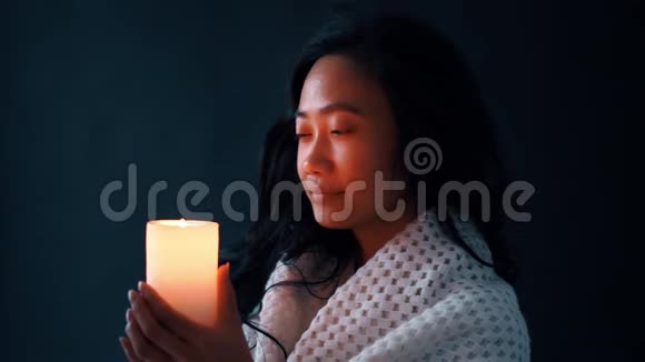美丽的年轻女子喜欢在黑暗中点燃蜡烛视频的预览图