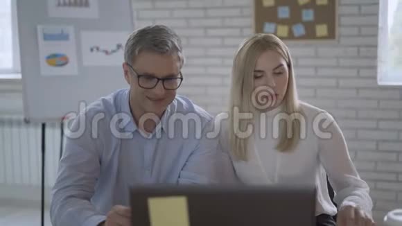 在线会议笔记本电脑前的一男一女正在和同事交谈4K视频的预览图