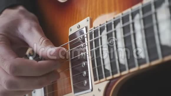 手指式吉他手在吉他上练习歌曲双手挑拨吉他弦关闭视野音乐概念视频的预览图