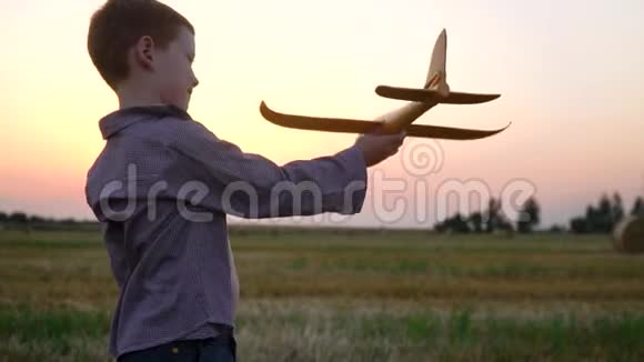这个红头发的男孩在麦田里玩玩具飞机上面有捆慢动作视频的预览图