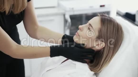 闭上美容师的手检查和触摸病人脸视频的预览图