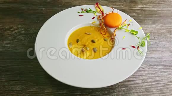 用白色塑料勺子把南瓜奶油汤放在深碗里视频的预览图