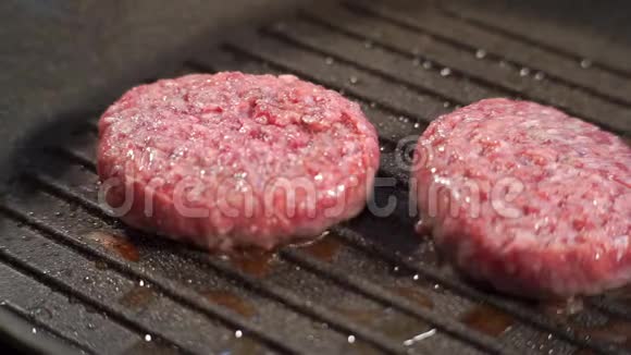 两个多汁的碎肉片用油煎在烤架上视频的预览图