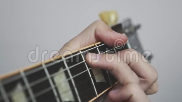 双手在吉他上弹奏和弦微动板和床头柜吉他手用吉他演奏歌曲视频的预览图