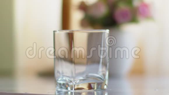 一个人从一个透明的水壶里倒水到水玻璃里视频的预览图