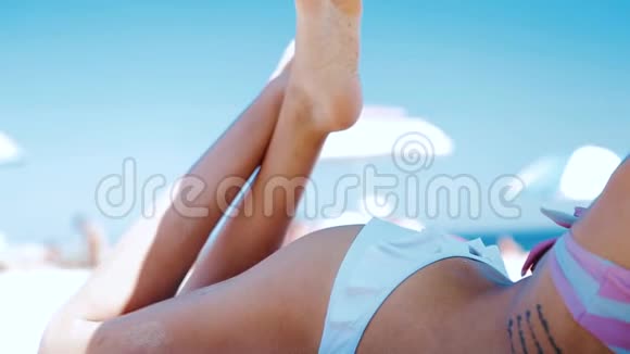 夏季美丽的运动女子在沙滩上晒比基尼性感苗条身材的模特视频的预览图