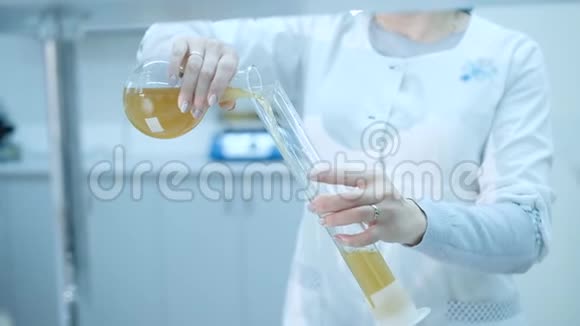 实验室助理从烧瓶中倒入液体实验室酿酒厂视频的预览图