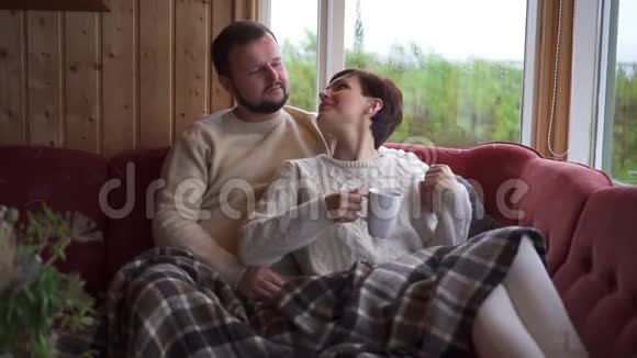 一对夫妇坐在家里的沙发上拥抱视频的预览图