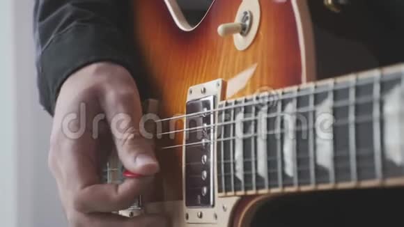 人手用pick演奏电吉他pick和strumming男性手和吉他弦与皮卡演奏摇滚歌曲音乐剧视频的预览图