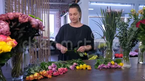 花商在花店里准备花束把玫瑰花刺放在桌子上视频的预览图