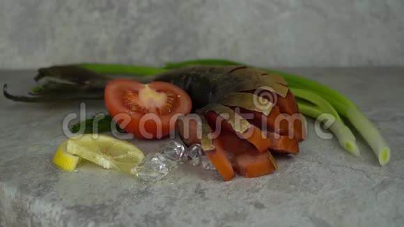 美味的熏鱼在桌子上西红柿和洋葱被添加到开胃菜中用冰块装饰视频的预览图