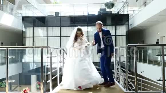 布鲁内特新娘和英俊的房间跳舞有趣的舞蹈在酒店大堂漂亮的新婚夫妇时髦的视频的预览图