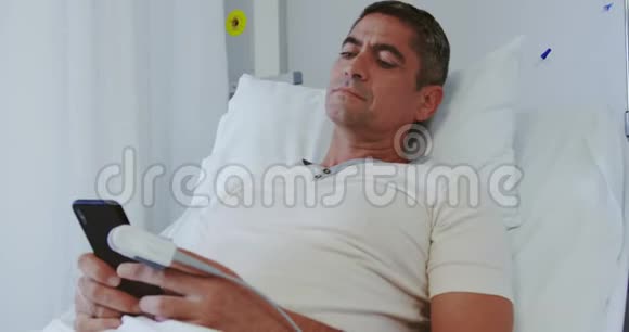 在医院病房使用手机的男性病人视频的预览图