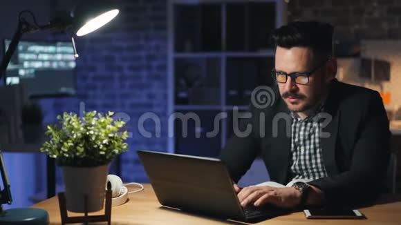 一幅疲惫的家伙在笔记本电脑上打哈欠晚上睡在电脑上的画像视频的预览图