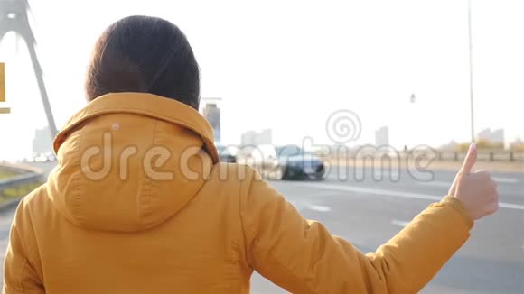 女孩把车停下来搭便车慢动作拇指向上视频的预览图