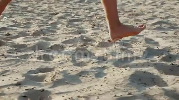 一个赤脚女人的脚在沙滩上奔跑的侧面景色赤足运动型越野车视频的预览图