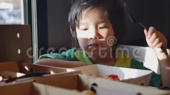 一个亚洲小女孩喜欢自己在餐馆吃披萨视频的预览图