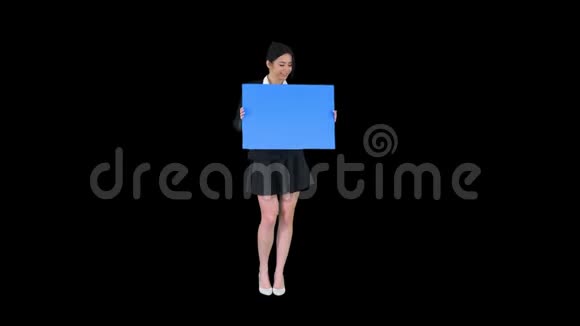 一个时尚的女人跳舞拿着空海报阿尔法频道视频的预览图