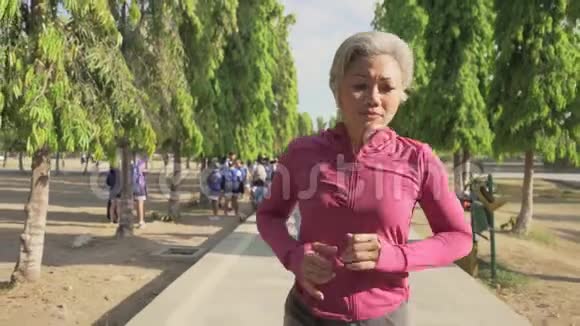 索洛莫万向节跟踪迷人的中年女士在城市公园跑步快乐40多岁的美女正在慢跑视频的预览图
