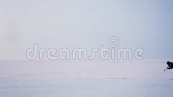 白种人音乐家独自在雪地上行走在冰冻的湖底积极地吹喇叭视频的预览图