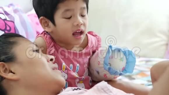 亚洲母亲通过阅读和讲故事的方式给她的小女孩亲子关系读睡前故事视频的预览图
