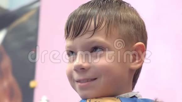 理发师在男孩的头上用剪刀剪头发正面视图造型师手特写视频的预览图