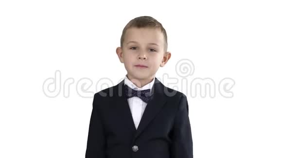 穿着制服戴着蝴蝶结的小男孩走在白色背景上视频的预览图