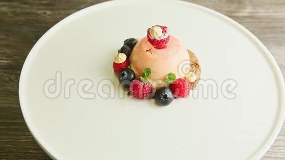 从结冰的甜点中放大用浆果装饰得很好在盘子上旋转视频的预览图