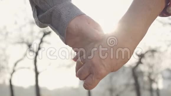 两只成熟的手在阳光下紧紧地握在一起高加索族的统一一起衰老永恒视频的预览图