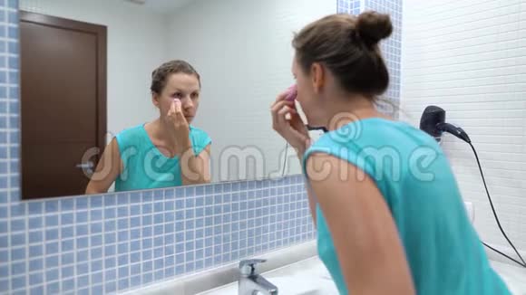 女人做一个早晨的例行公事刷牙化妆和头发视频的预览图