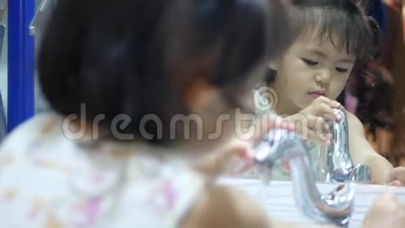 小亚洲女孩喜欢自己打开水龙头和洗手视频的预览图