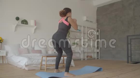 运动健美女在室内做深蹲运动视频的预览图