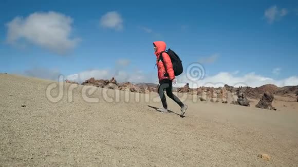一名年轻女子背着背包徒步旅行在一个巨大的泰德火山口的火山岩中徒步旅行视频的预览图
