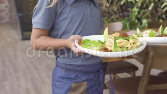 女服务员在餐厅桌上招待小孩小男孩和小女孩在咖啡馆里吃东西快乐的孩子们视频的预览图