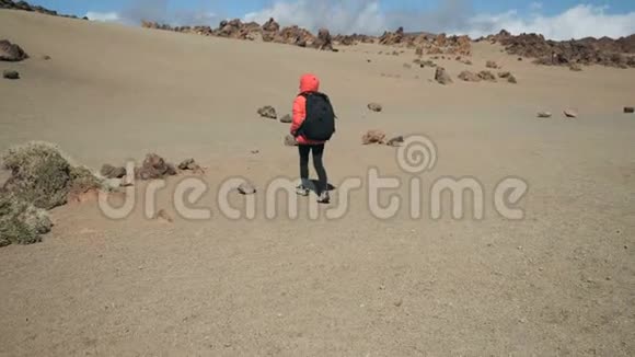 一名年轻女子背着背包徒步旅行在一个巨大的泰德火山口的火山岩中徒步旅行视频的预览图