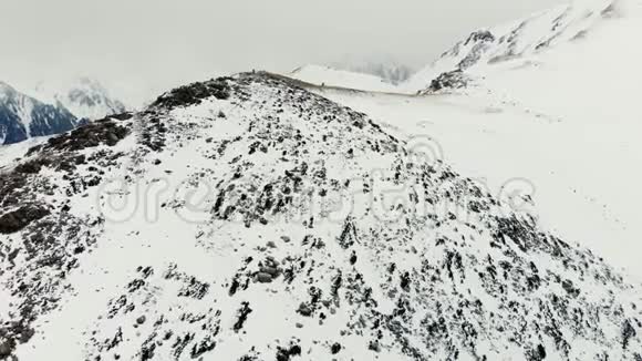 冬天的山脉在阴天的冬天游客们爬山视频的预览图