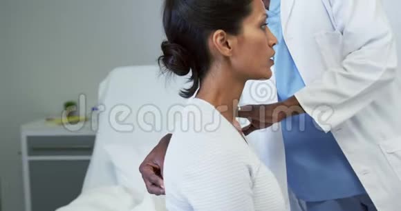 非裔美国男医生在医院病房检查女病人的正面看法视频的预览图