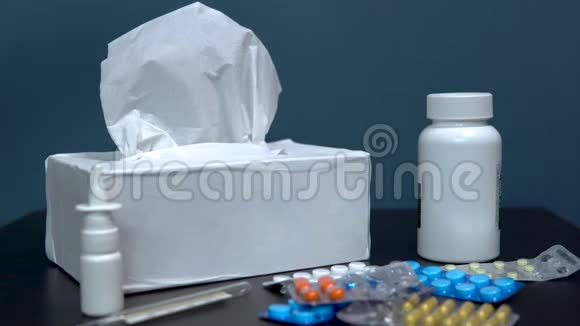 女人拿纸巾在桌子上吃药用于治疗疾病的多色药片放在桌子上视频的预览图