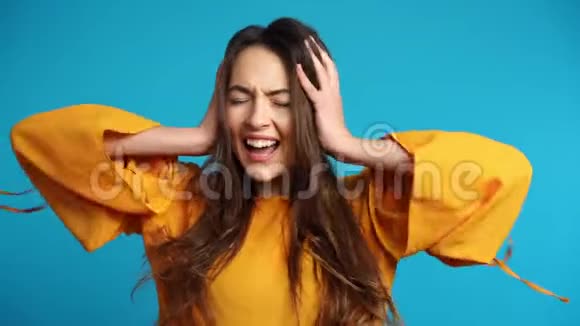 失望的压力女人用双手捂住耳朵蓝底视频的预览图