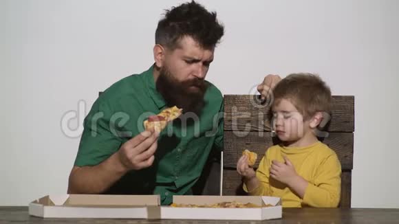 父子共进午餐给孩子吃披萨人午餐留胡子的人是在餐桌上吃饭的小男孩意大利视频的预览图