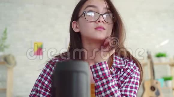 肖像美丽的亚洲女孩戴眼镜长发在客厅现代阅读一本书享受声音视频的预览图