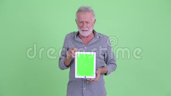 快乐的大胡子男人一边说一边展示数字平板电脑视频的预览图