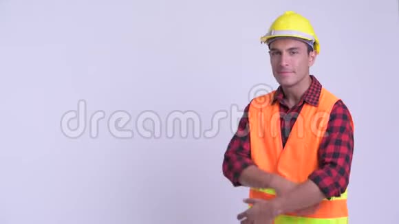 年轻快乐的西班牙裔建筑工人双臂交叉微笑视频的预览图