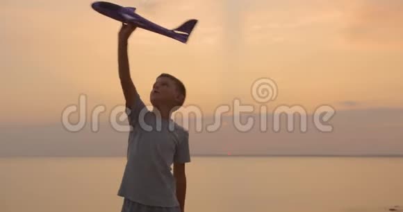 快乐的孩子在橙色阳光下玩玩具飞机最好的童年概念视频的预览图