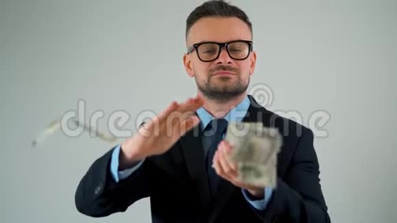 穿着得体的人动作缓慢把一美元的钞票散落在他的周围赚钱视频的预览图
