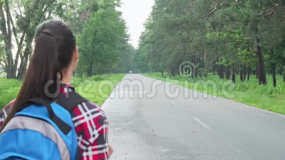 快乐的女性背包客欣赏大自然在乡间小路上行走视频的预览图