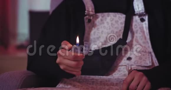 特写沙发上的一个家伙在镜头前玩打火机打火机火视频的预览图