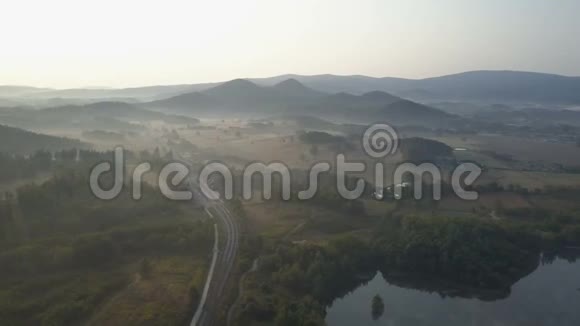 湖旁山上火车站的空中景色山脉中雾状的日出视频的预览图